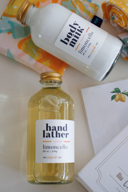 Close-up of Limoncello Hand Lather and Limoncello Body Milk bottles from The Scrub Bar, included in The Capri Tasting Gift Set. This lemon-themed gift set features a luxurious lemon-scented body care collection perfect for gifting.